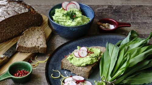 KI generiert: Das Bild zeigt eine Nahaufnahme von frischen Lauchstangen, die mit Wassertropfen bedeckt sind. Die Stängel sind dicht aneinander gereiht und ihre grünen Blätter sind gut sichtbar.