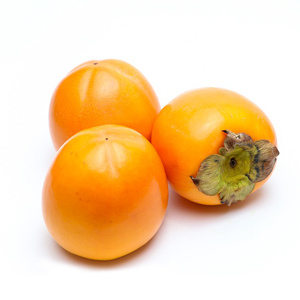 KI generiert: Drei gelbe Kakis liegen auf weißem Hintergrund.