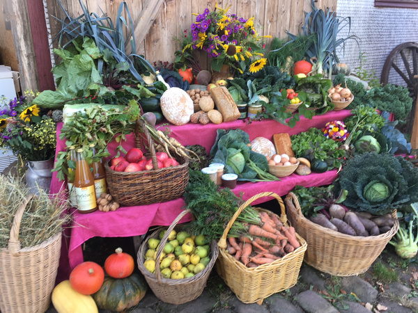KI generiert: Vielfältige Sammlung von frischem Obst, Gemüse, Brot und Blumen auf einem Marktstand.