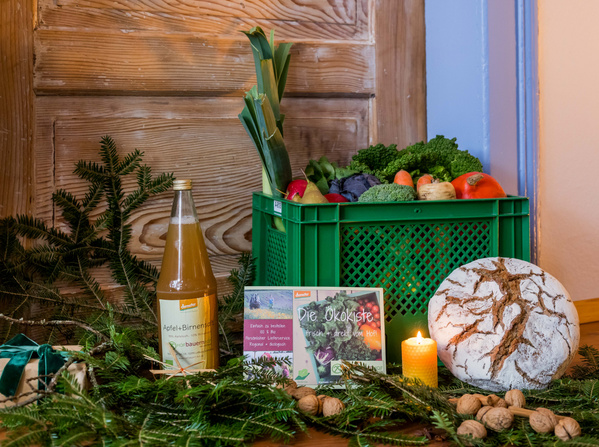 KI generiert: Das Bild zeigt eine Küchenszene, in der jemand Gurken und andere Gemüse auf einem Schneidebrett würfelt. Im Vordergrund steht ein Teller mit geschnittenen Gurken, Tomaten und Paprika.