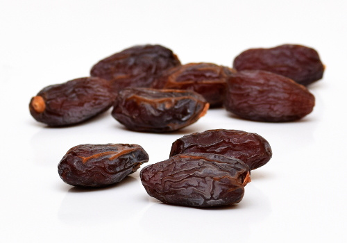 KI generiert: Getrocknete Datteln auf einer weißen Oberfläche.