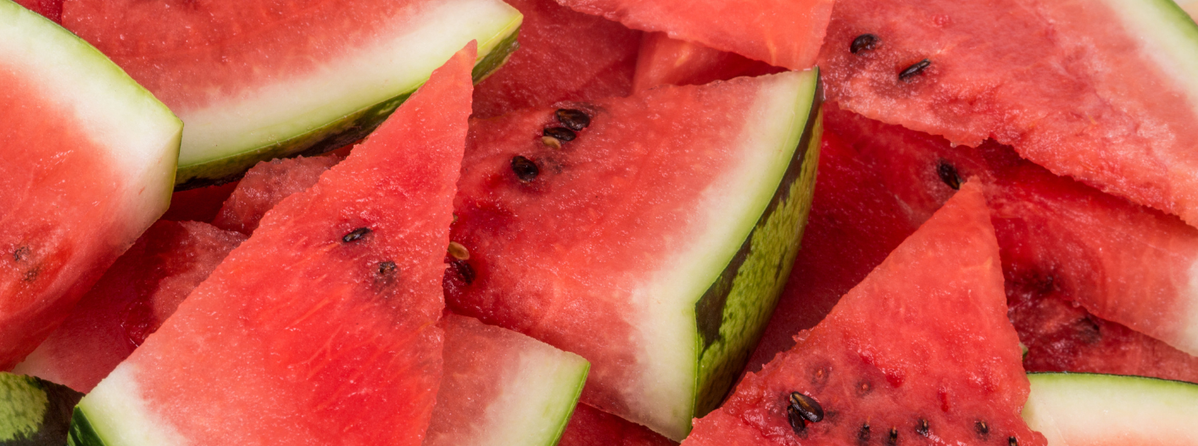 KI generiert: Mehrere Wassermelonenstücke mit grüner Schale und schwarzen Kernen.