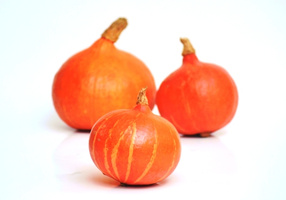 KI generiert: Drei orangefarbene Kürbisse auf weißem Hintergrund.