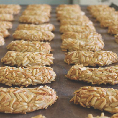 KI generiert: Ein Tablett voller Kekse, die mit Mandelsplittern bedeckt sind.