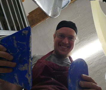 KI generiert: Zwei Personen arbeiten in einer Bäckerei und bereiten Teig mit einer Füllung vor. Der Raum ist mit Backutensilien und Geräten ausgestattet.