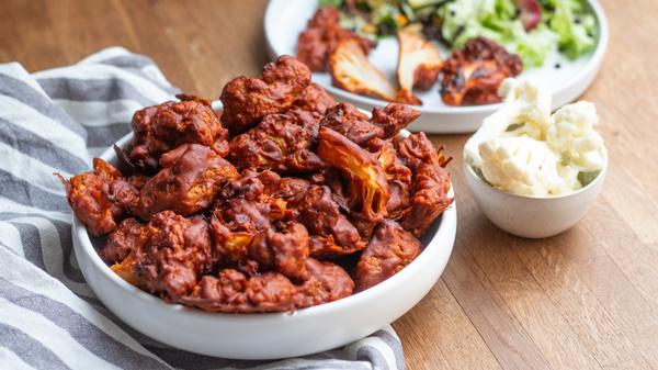 KI generiert: Das Bild zeigt eine Nahaufnahme von frischen Lauchstangen, die mit Wassertropfen bedeckt sind. Die Stängel sind dicht aneinander gereiht und ihre grünen Blätter sind gut sichtbar.